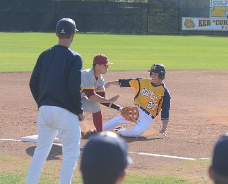 Head baseball coach Gary Rath looks on as Jacob Swiney slides into third base vs. Jones Mar. 29.